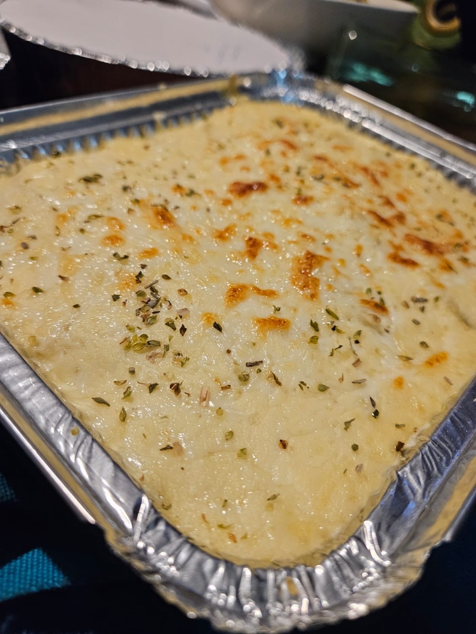 Creamy herb-topped catering bake in a serving tray