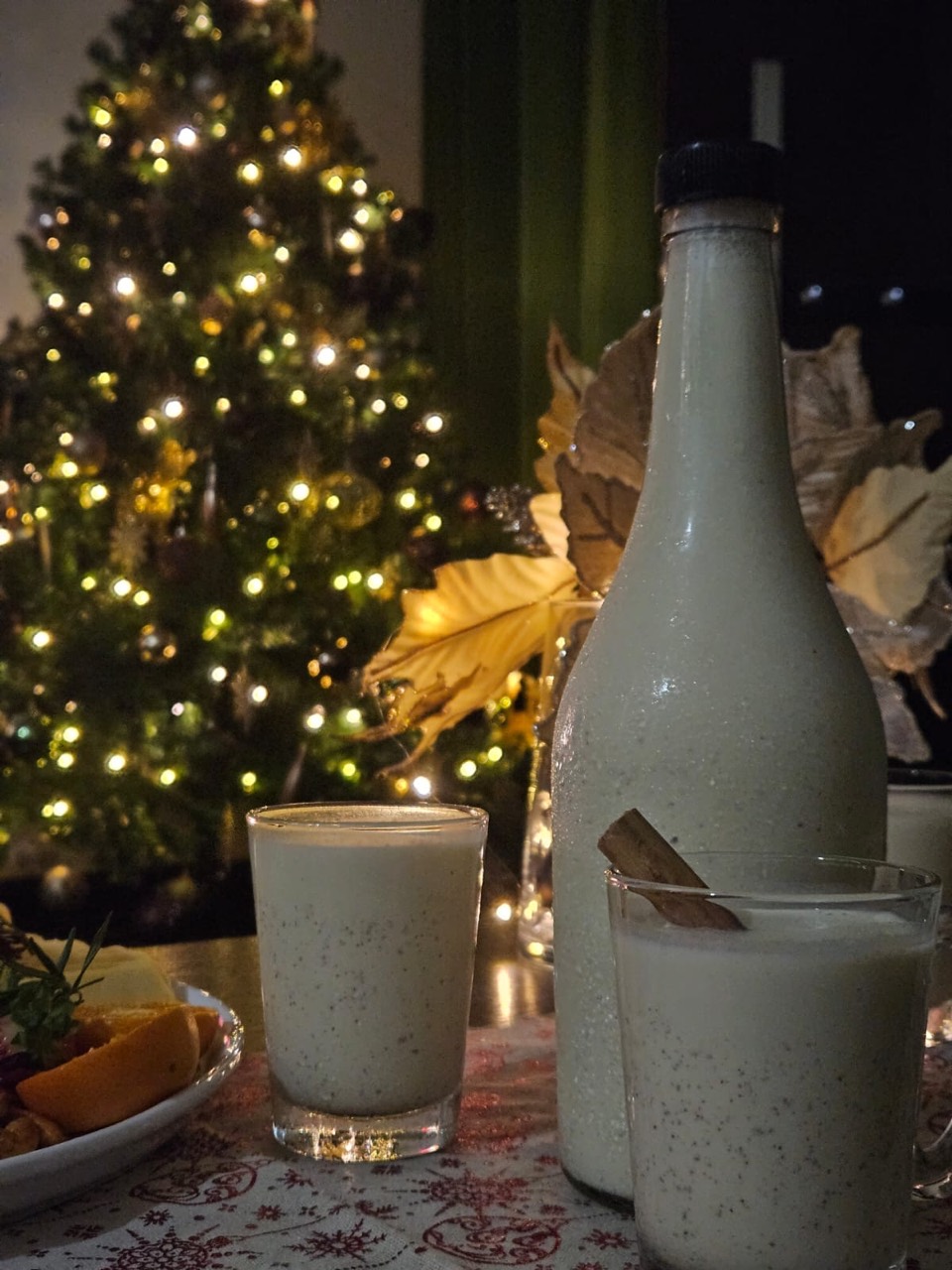 Chilled festive drinks served beside a glowing Christmas tree