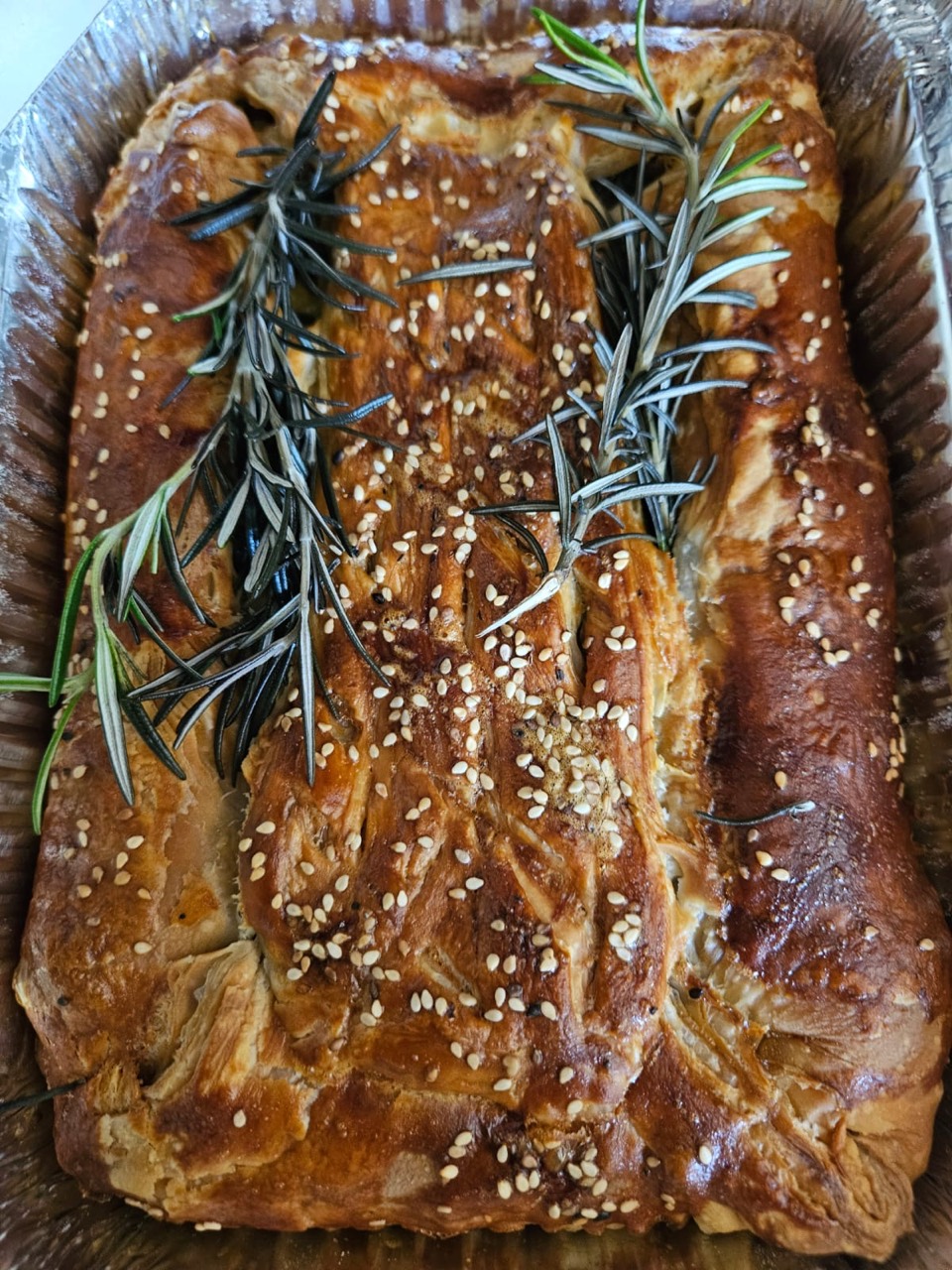 Golden savoury pastry topped with sesame seeds and rosemary