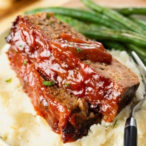 Glazed meatloaf served with creamy mash and green beans