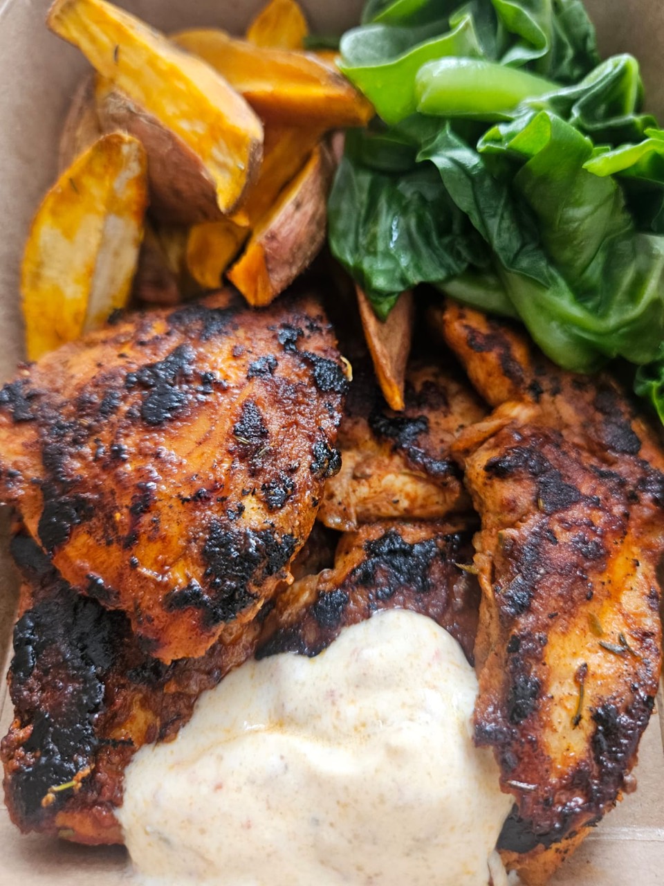 Grilled chicken with roasted sweet potato, greens, and a creamy sauce